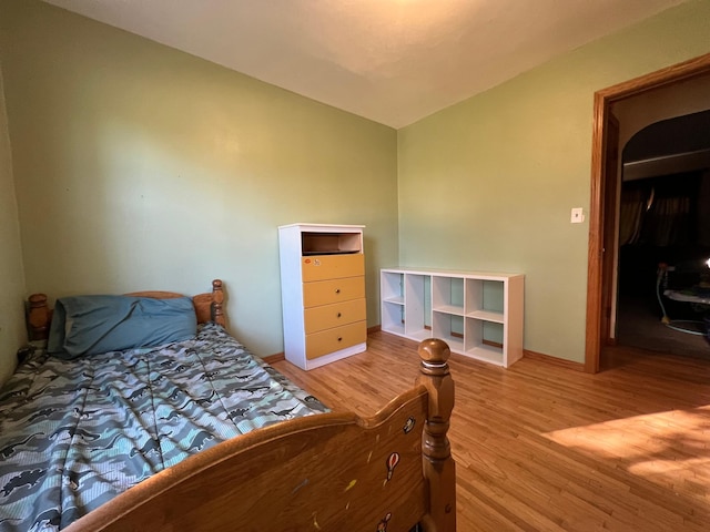 bedroom featuring wood-type flooring and vaulted ceiling