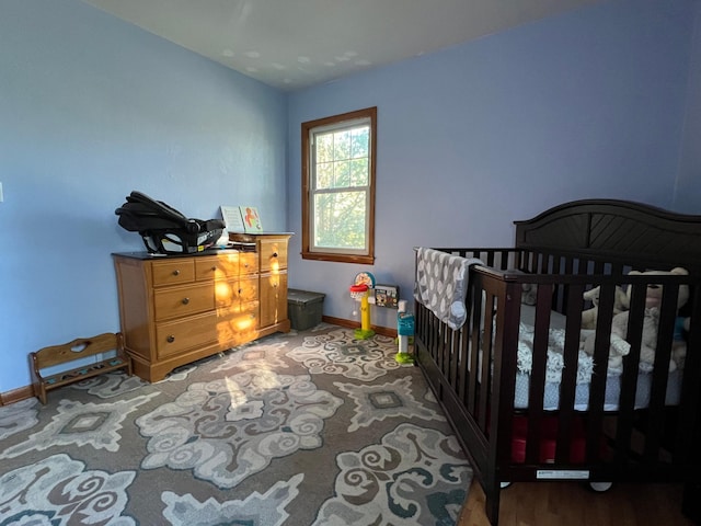 bedroom featuring a nursery area and hardwood / wood-style flooring