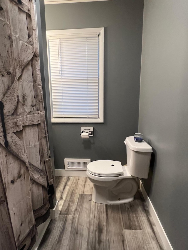 bathroom featuring hardwood / wood-style floors and toilet