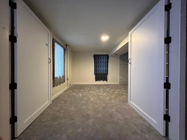 hallway with dark colored carpet