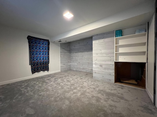 basement featuring carpet flooring and wooden walls