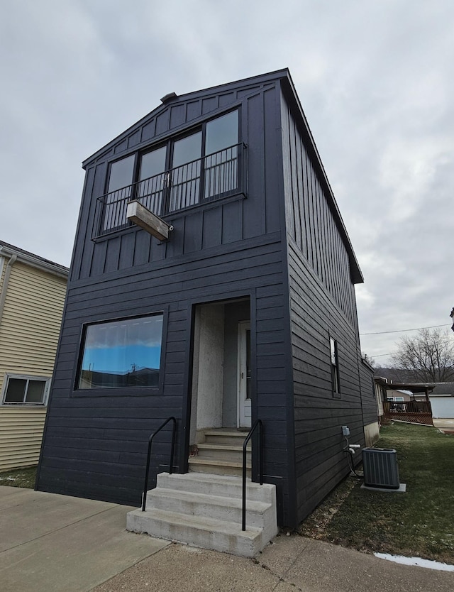 view of front of house featuring a balcony and central AC unit