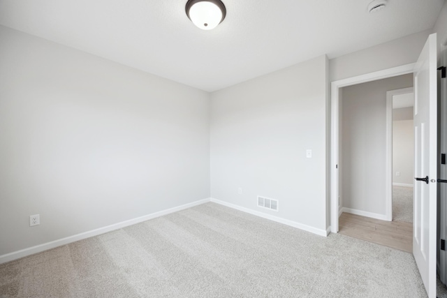 carpeted empty room with visible vents and baseboards