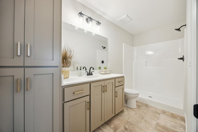 bathroom featuring a shower, vanity, and toilet