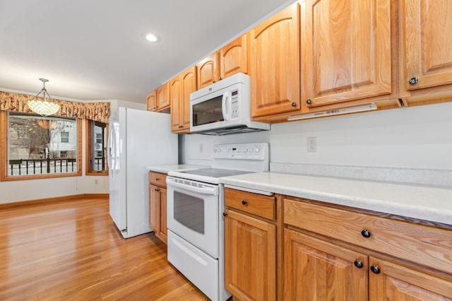 kitchen featuring white appliances, light hardwood / wood-style flooring, and hanging light fixtures