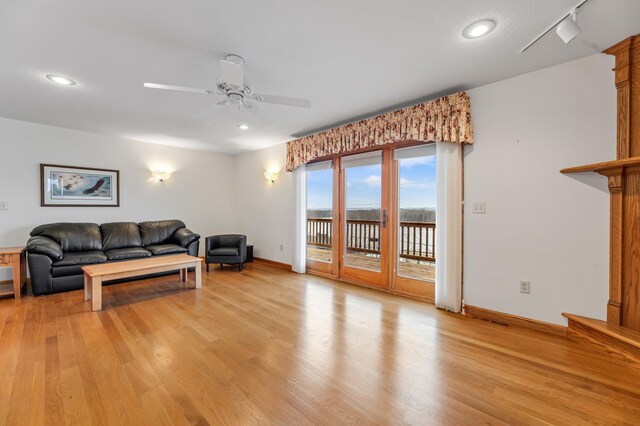 living room with ceiling fan and light hardwood / wood-style floors