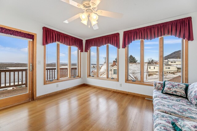 unfurnished sunroom with ceiling fan