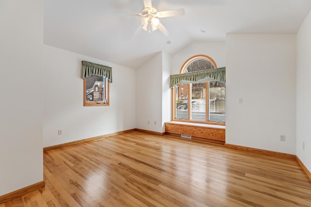 empty room with ceiling fan, vaulted ceiling, and hardwood / wood-style flooring