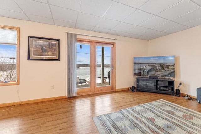 interior space featuring a paneled ceiling and light hardwood / wood-style floors