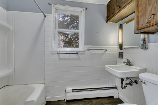 bathroom with toilet, tile walls, and a baseboard heating unit