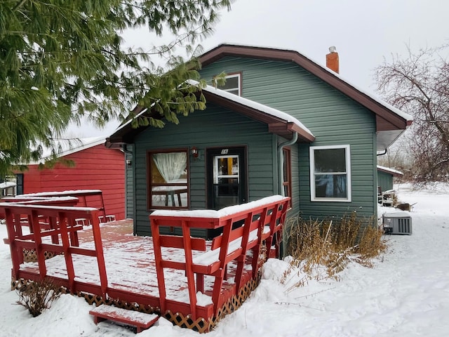 snow covered back of property with central air condition unit