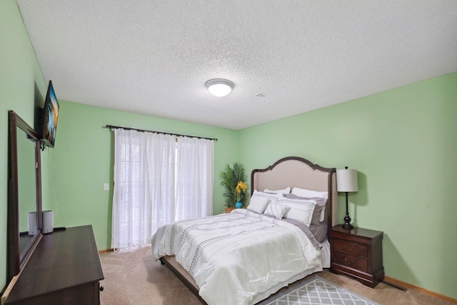 bedroom featuring light colored carpet and a textured ceiling