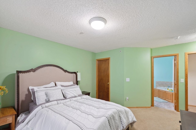 carpeted bedroom featuring ensuite bath and a textured ceiling