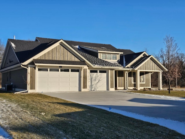 view of front of house featuring cooling unit, a front yard, and a garage