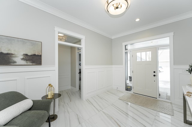 entryway with a wainscoted wall, ornamental molding, a decorative wall, and marble finish floor