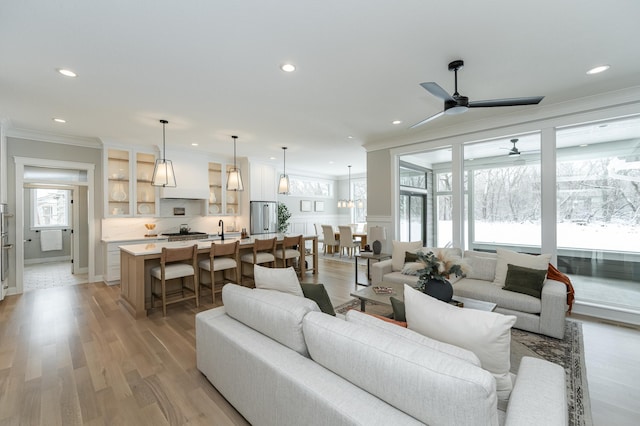 living room featuring recessed lighting, light wood-style flooring, and crown molding