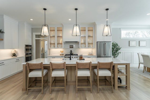 kitchen with stainless steel appliances, white cabinets, light countertops, and a sink