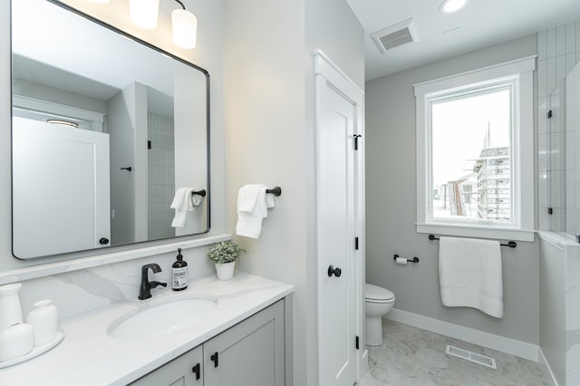 full bath featuring toilet, baseboards, visible vents, and vanity