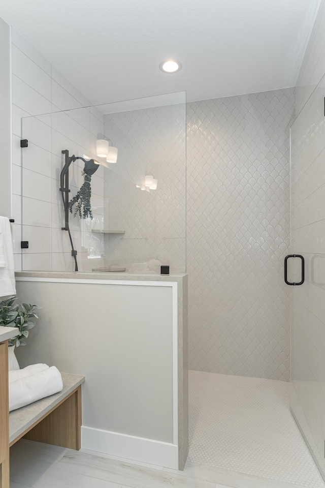 full bathroom with recessed lighting, tiled shower, and vanity