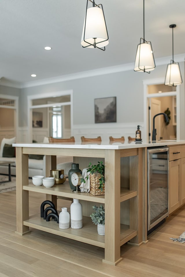 bar with light wood-type flooring, a sink, wine cooler, and crown molding