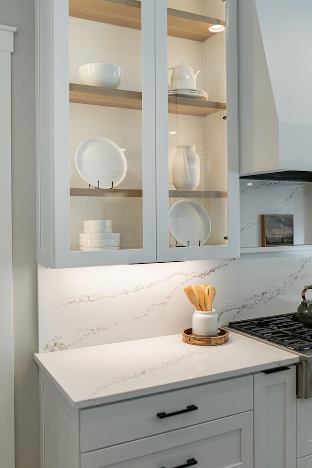 details with white cabinetry, decorative backsplash, and open shelves