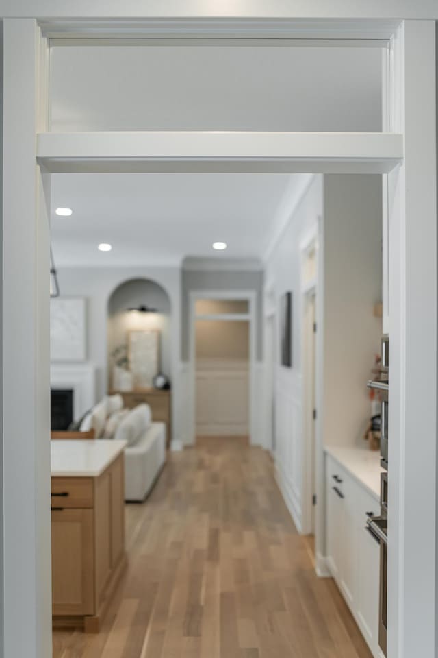 hallway featuring light wood-type flooring and recessed lighting