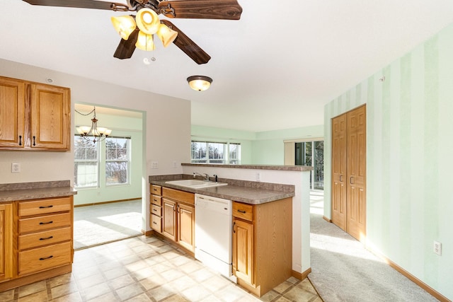 kitchen with dishwasher, ceiling fan with notable chandelier, light colored carpet, and sink