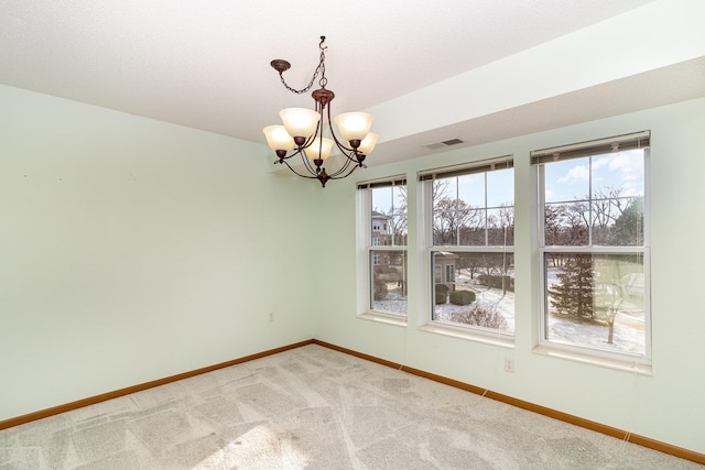 unfurnished dining area featuring a chandelier and carpet