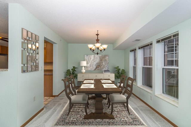 carpeted dining space featuring a chandelier