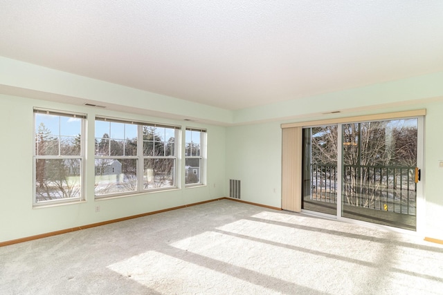 carpeted empty room with a textured ceiling