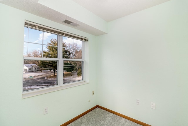 carpeted spare room with a textured ceiling