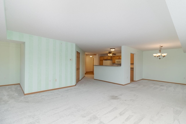 unfurnished living room with carpet and ceiling fan with notable chandelier