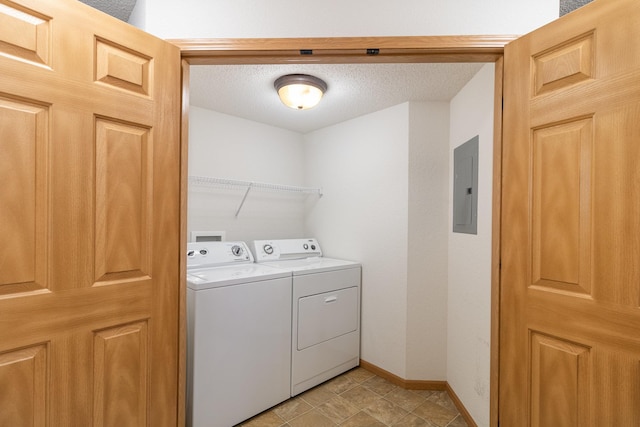 laundry room with electric panel, separate washer and dryer, and a textured ceiling