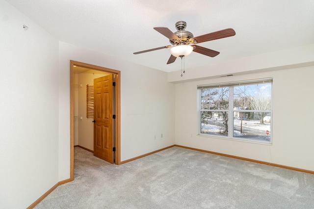 carpeted spare room with ceiling fan and a textured ceiling