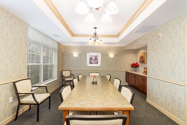 carpeted dining space with an inviting chandelier and a tray ceiling