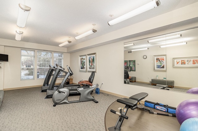 exercise area featuring carpet and a textured ceiling