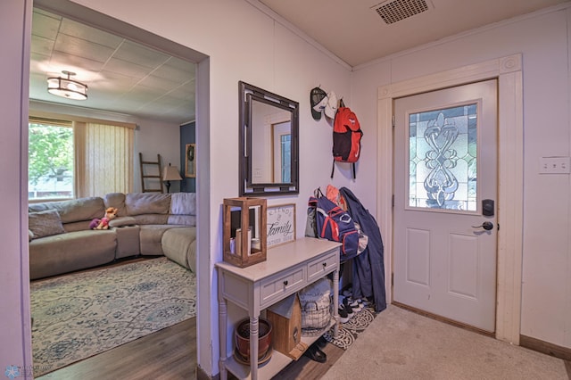 foyer entrance with hardwood / wood-style floors and ornamental molding