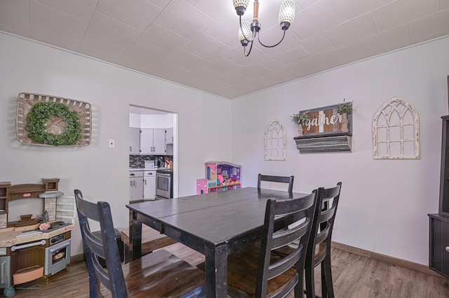 dining space with hardwood / wood-style flooring and a notable chandelier