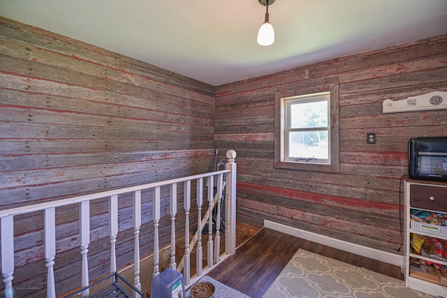 staircase with wood-type flooring and wooden walls