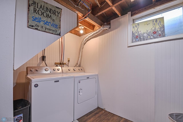 laundry room featuring washing machine and dryer, wood walls, and dark hardwood / wood-style floors