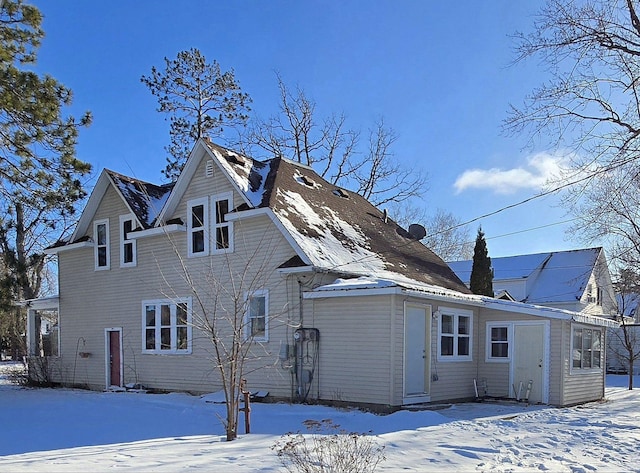 view of snow covered back of property