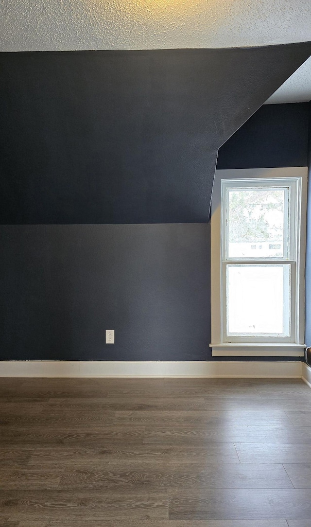 bonus room featuring a textured ceiling, hardwood / wood-style flooring, and lofted ceiling