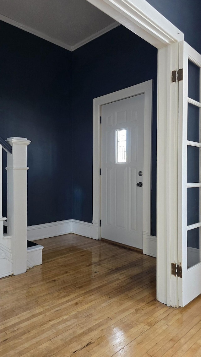 foyer featuring hardwood / wood-style floors and crown molding