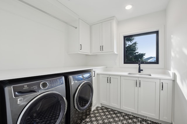 laundry room with washer and dryer, cabinets, and sink