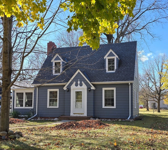 cape cod house featuring a front yard