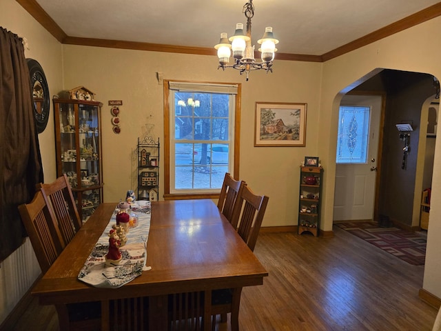 dining area featuring hardwood / wood-style flooring, a notable chandelier, and ornamental molding