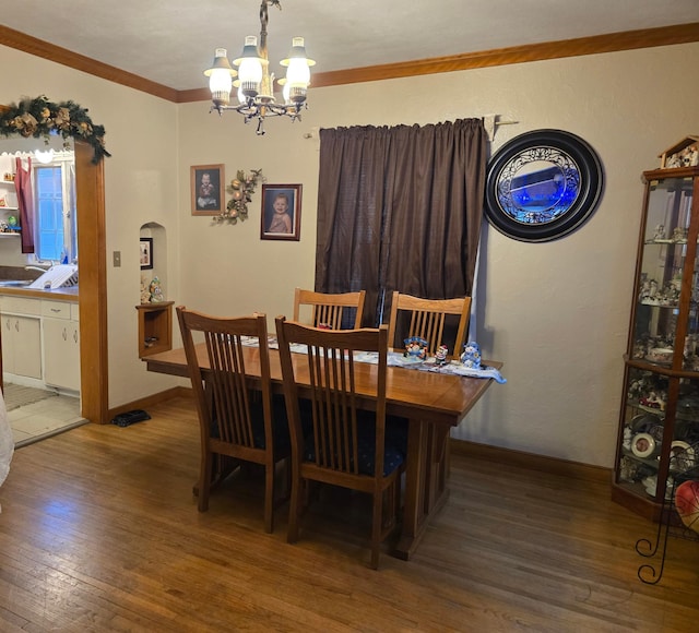 dining space with a chandelier, hardwood / wood-style floors, and ornamental molding