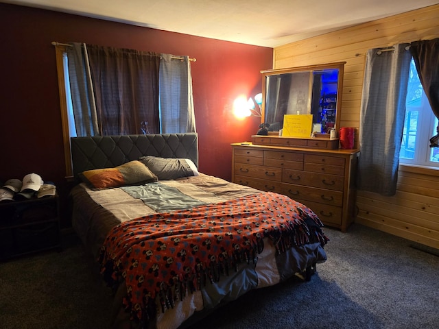 bedroom with wood walls and carpet floors