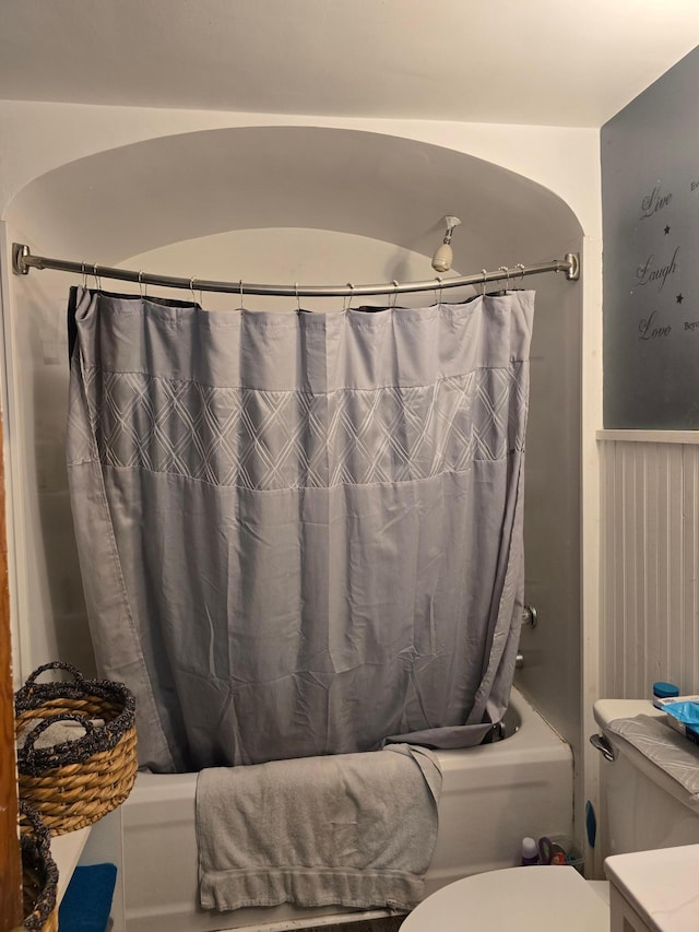 bathroom with shower / bath combo with shower curtain and toilet