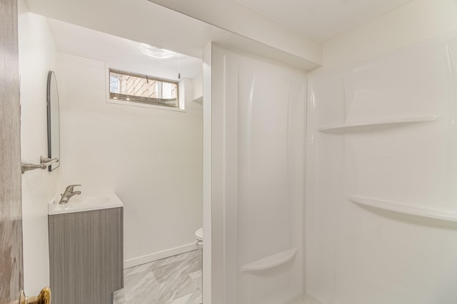 bathroom featuring vanity, toilet, and a shower